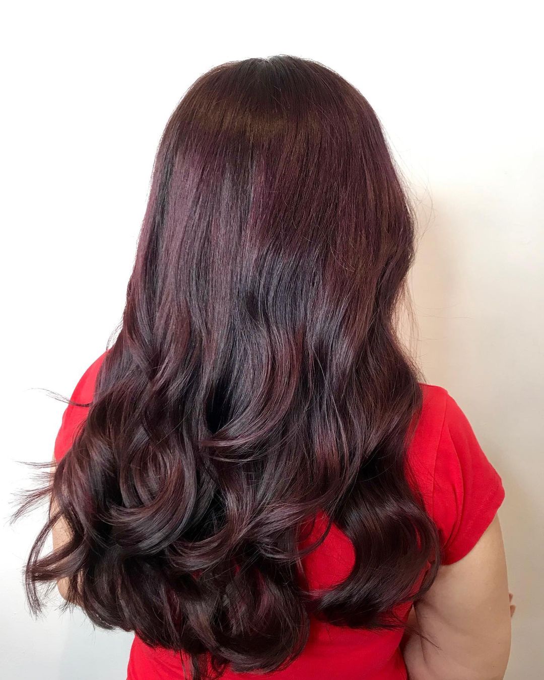 cheveux longs et ondulés de couleur brun cerise