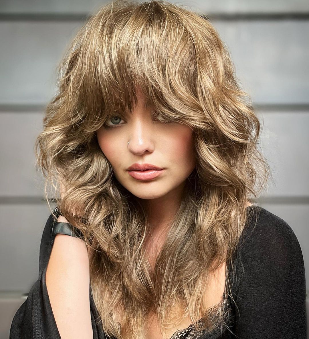 layered light brown wavy hair with full fringe