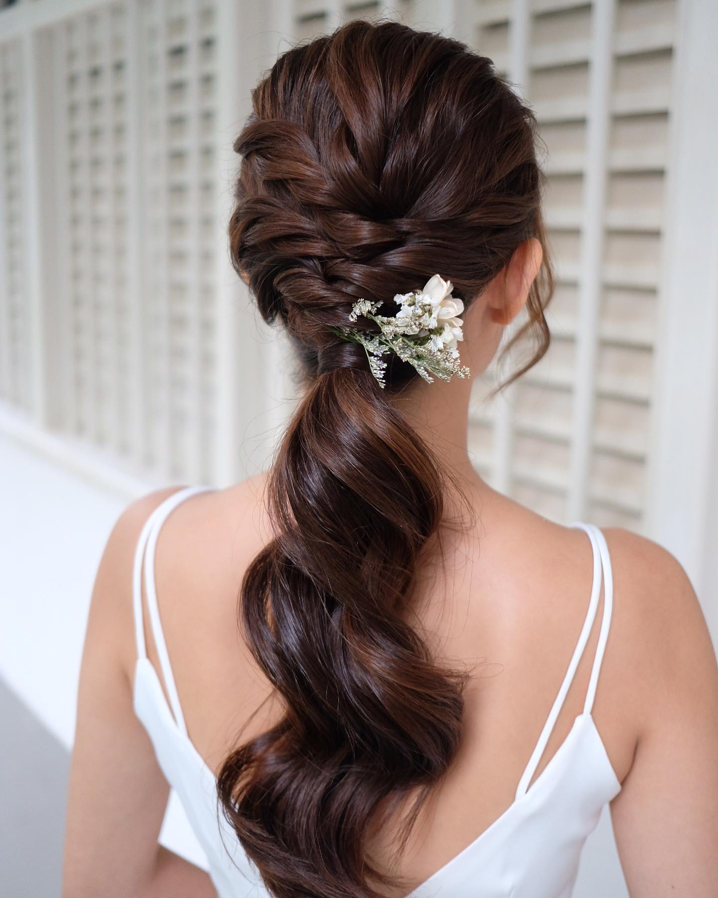 braid into ponytail with floral accessory