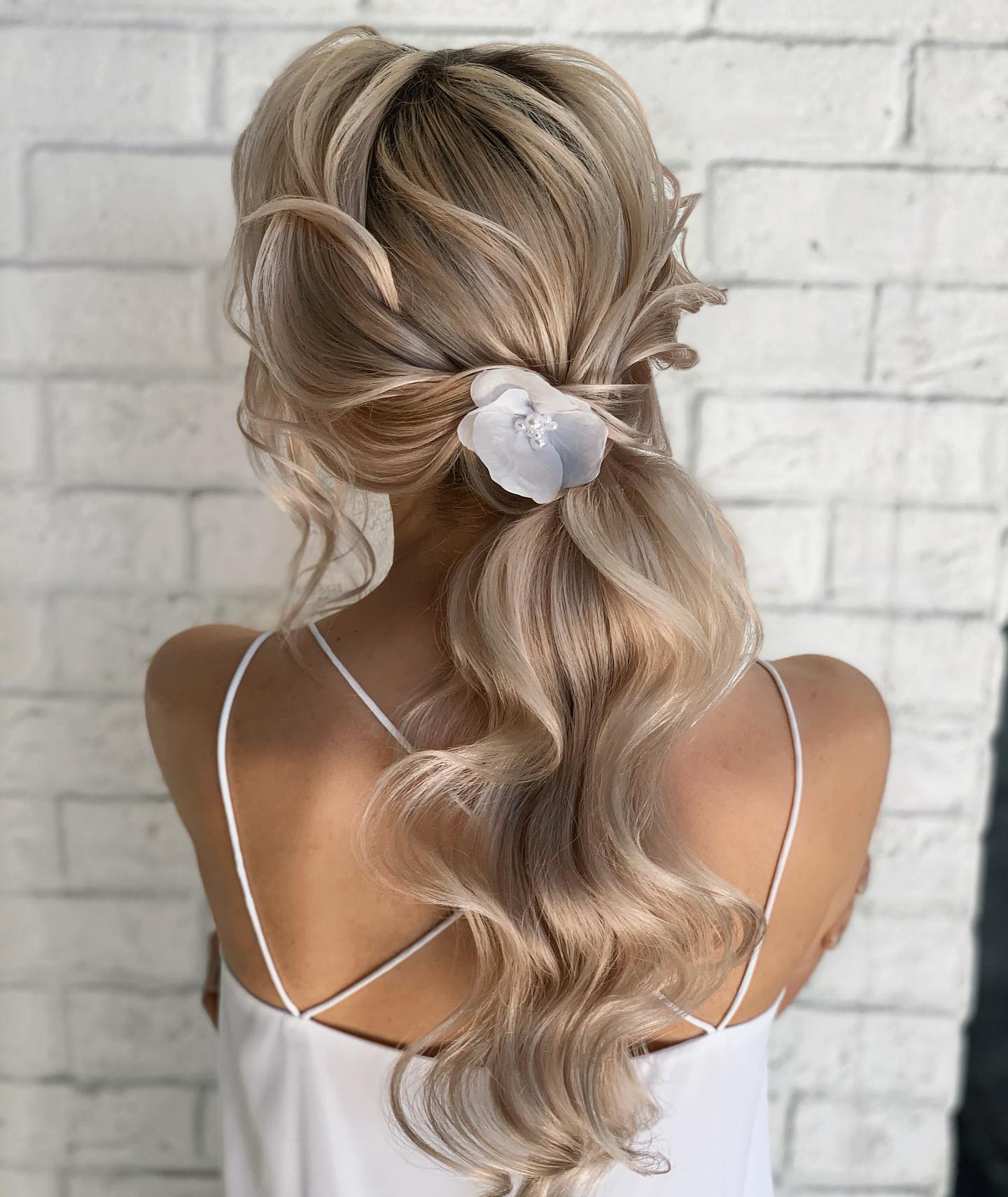curled low pony with a single flower
