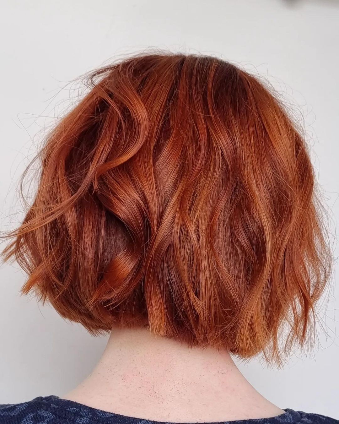 a woman with copper red blunt bob haircut