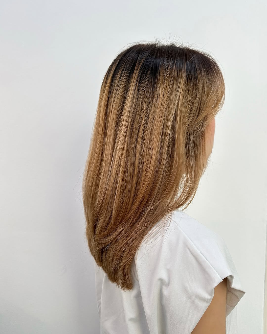 cabello a capas dimensional con raíces oscuras