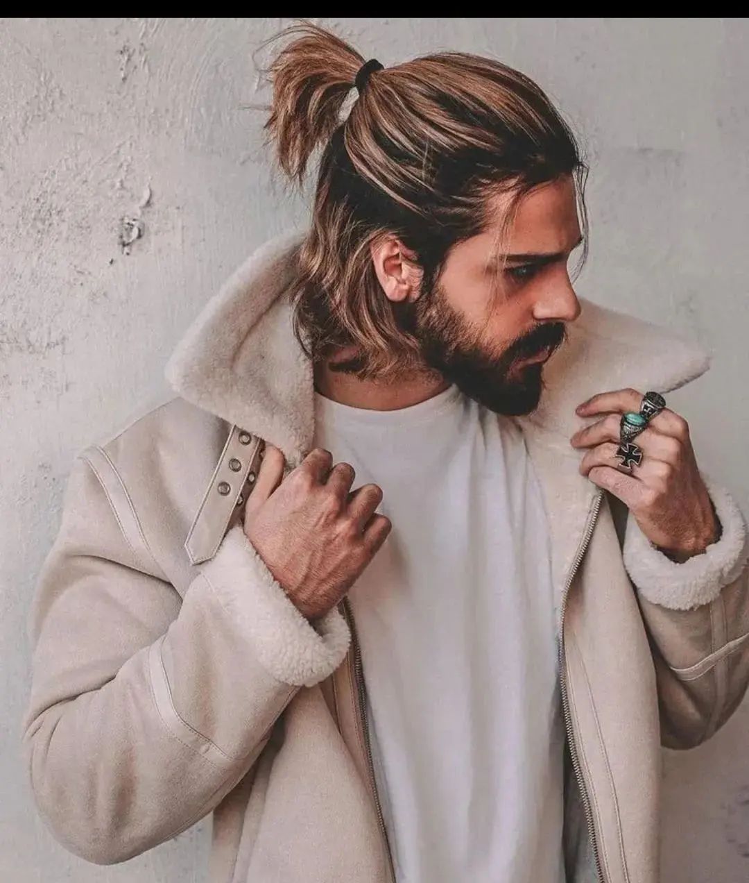 a man with half up ponytail for short wavy hair