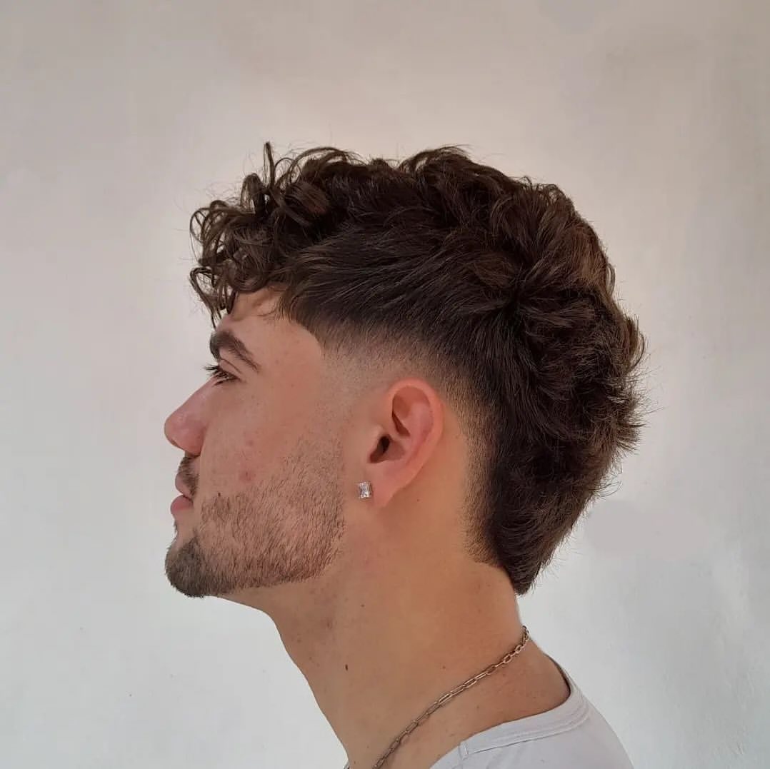a man with long wavy top and low taper haircut