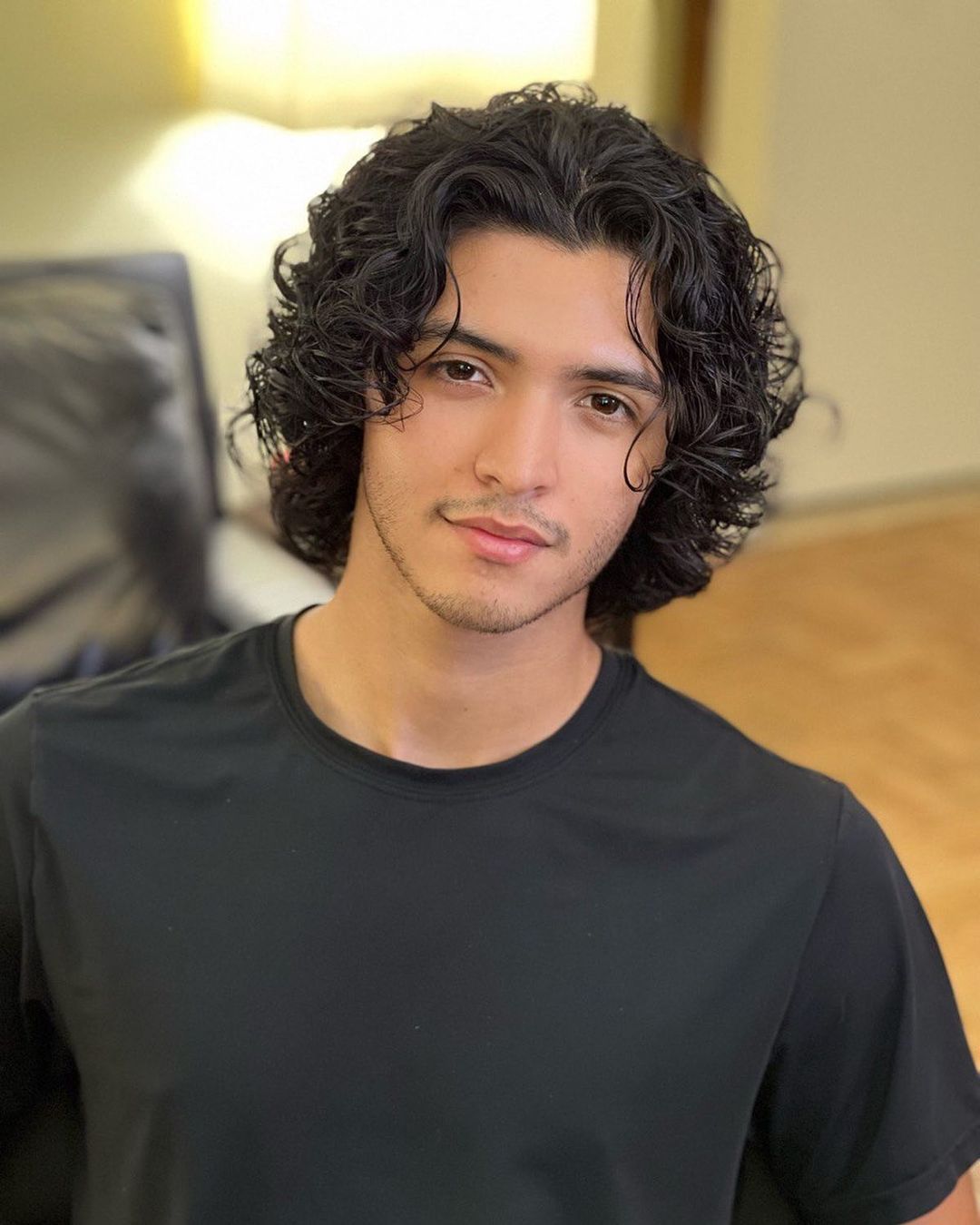 a man with medium wavy hair and a middle part