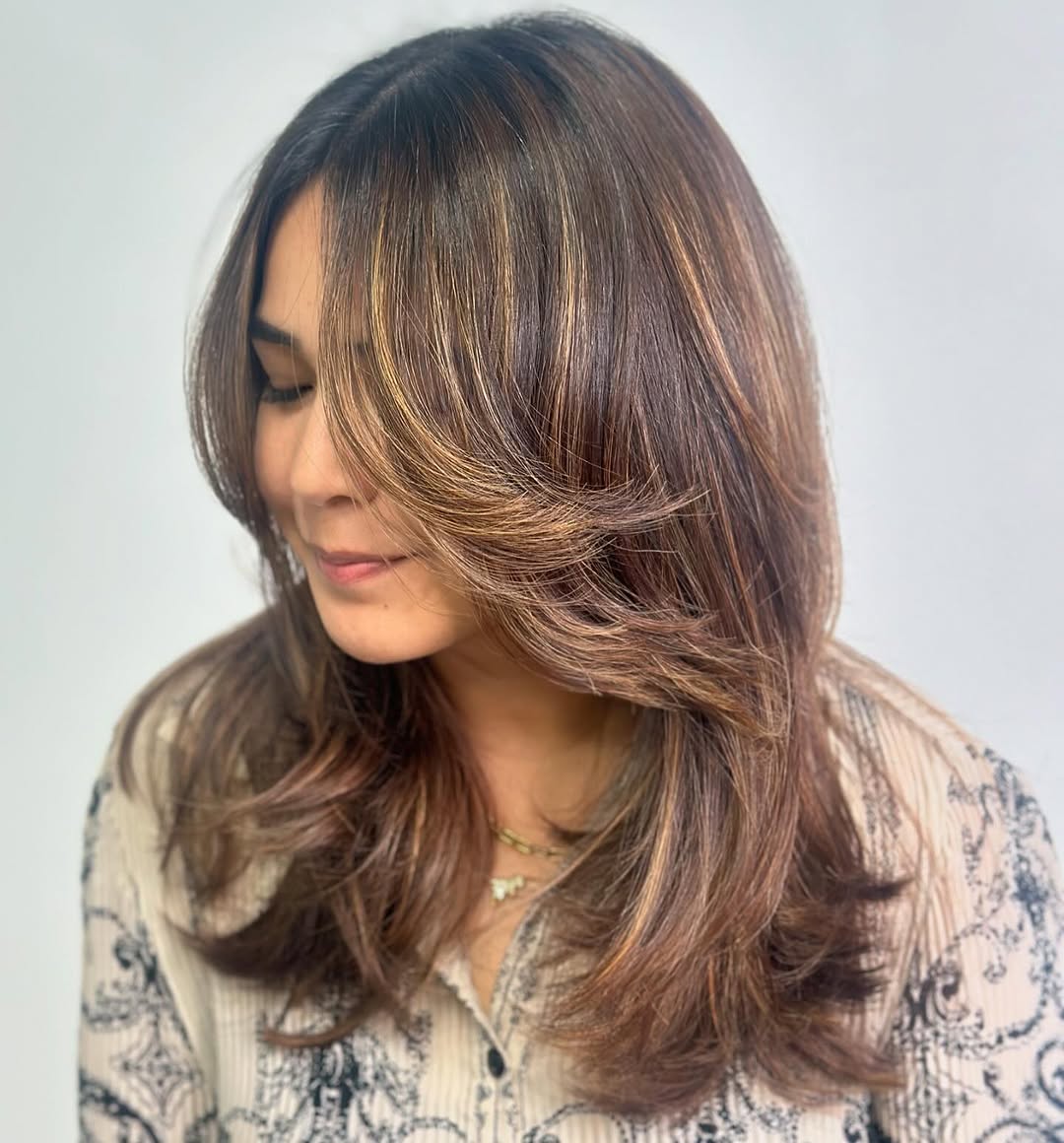 mid-length layered hair with feathered curtain bangs