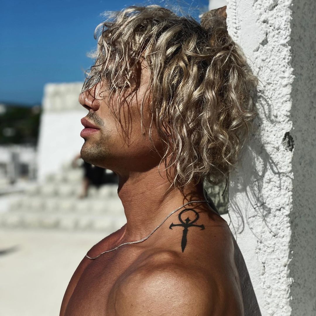 a man with silver blonde mid length wavy hair