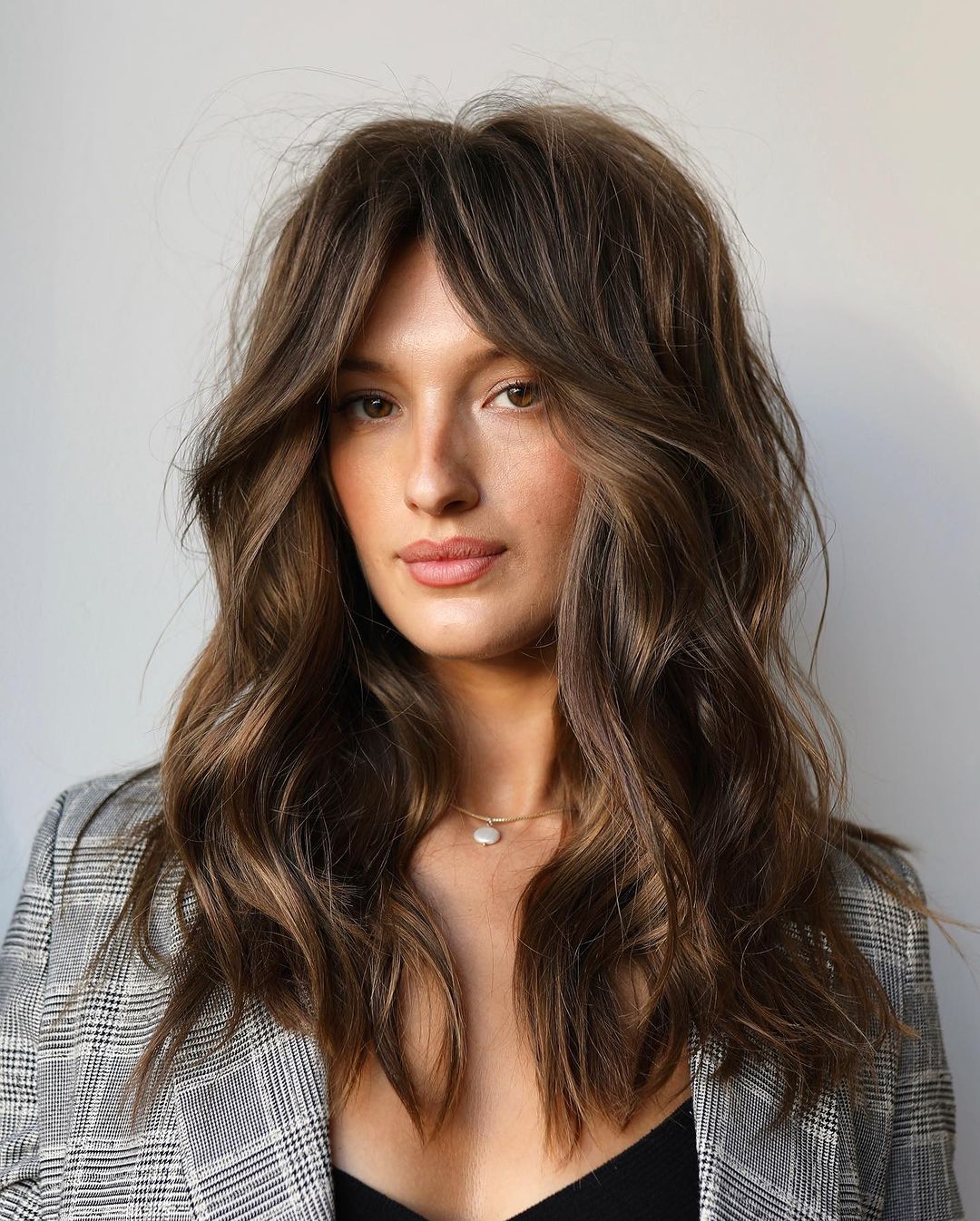 textured brown wavy hair with curtain bangs