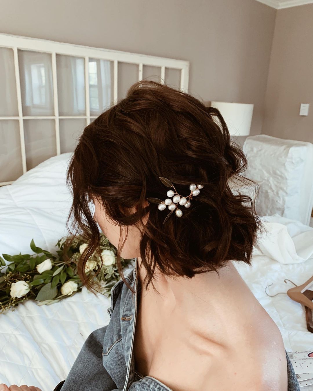 tousled short wavy hairstyle with a pearl hair pin