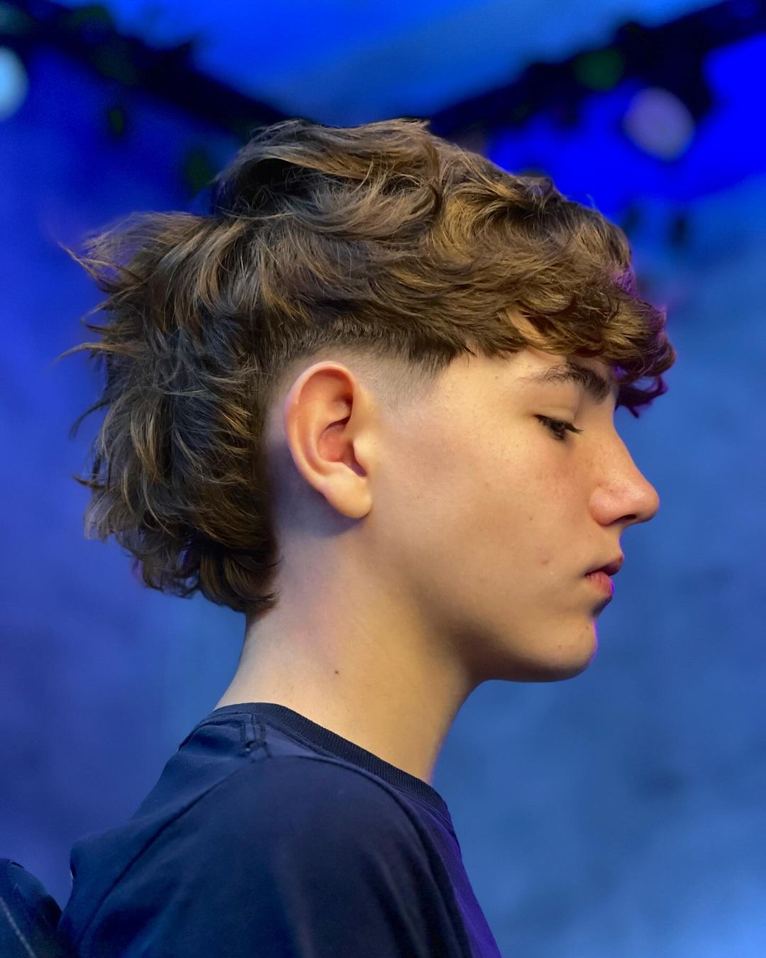 a boy with tousled wavy cut with longer back