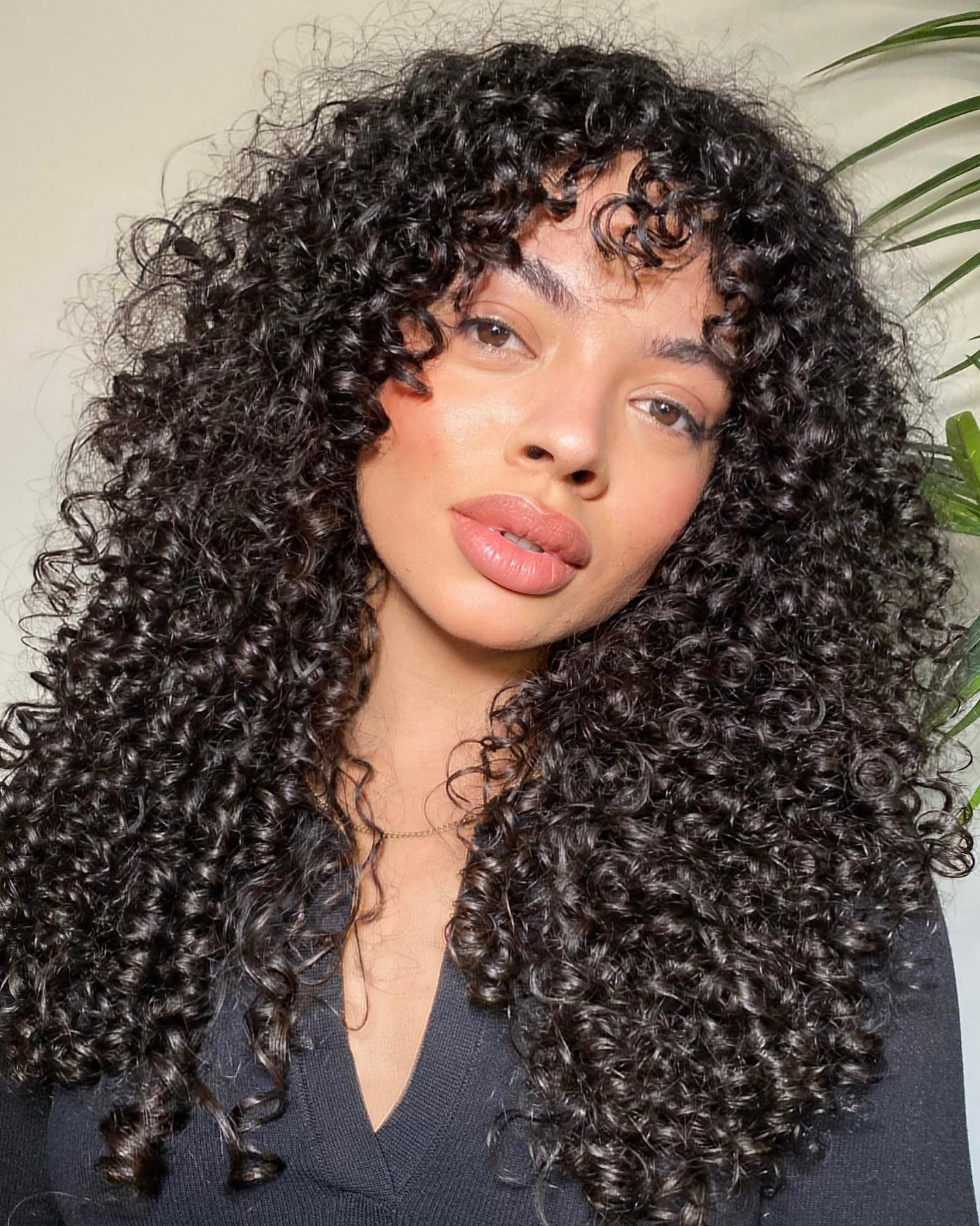 long layered curly hair with wispy bangs