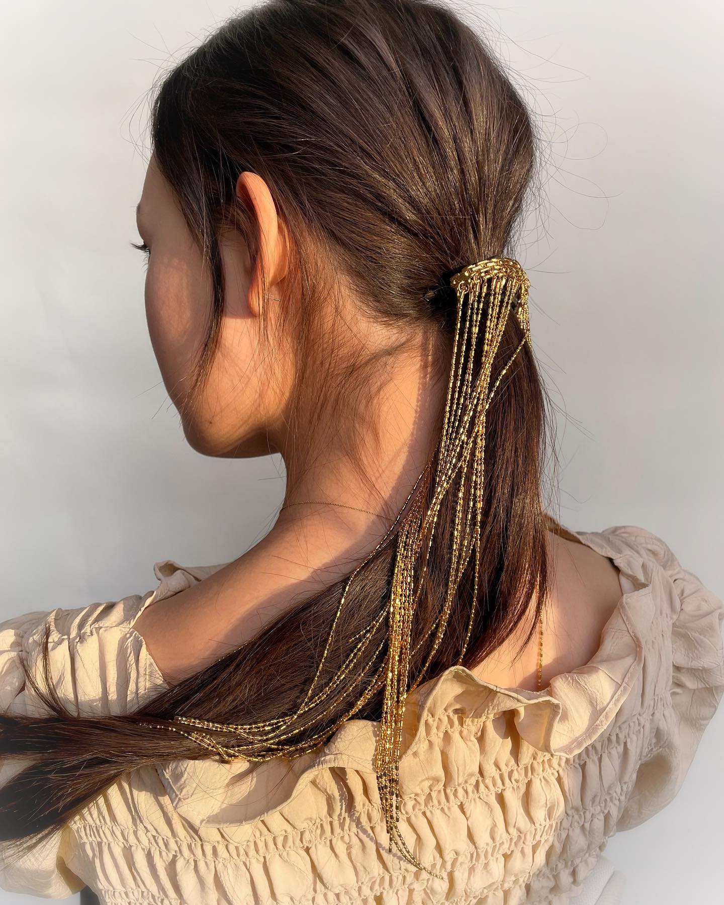 low ponytail with chain accessory