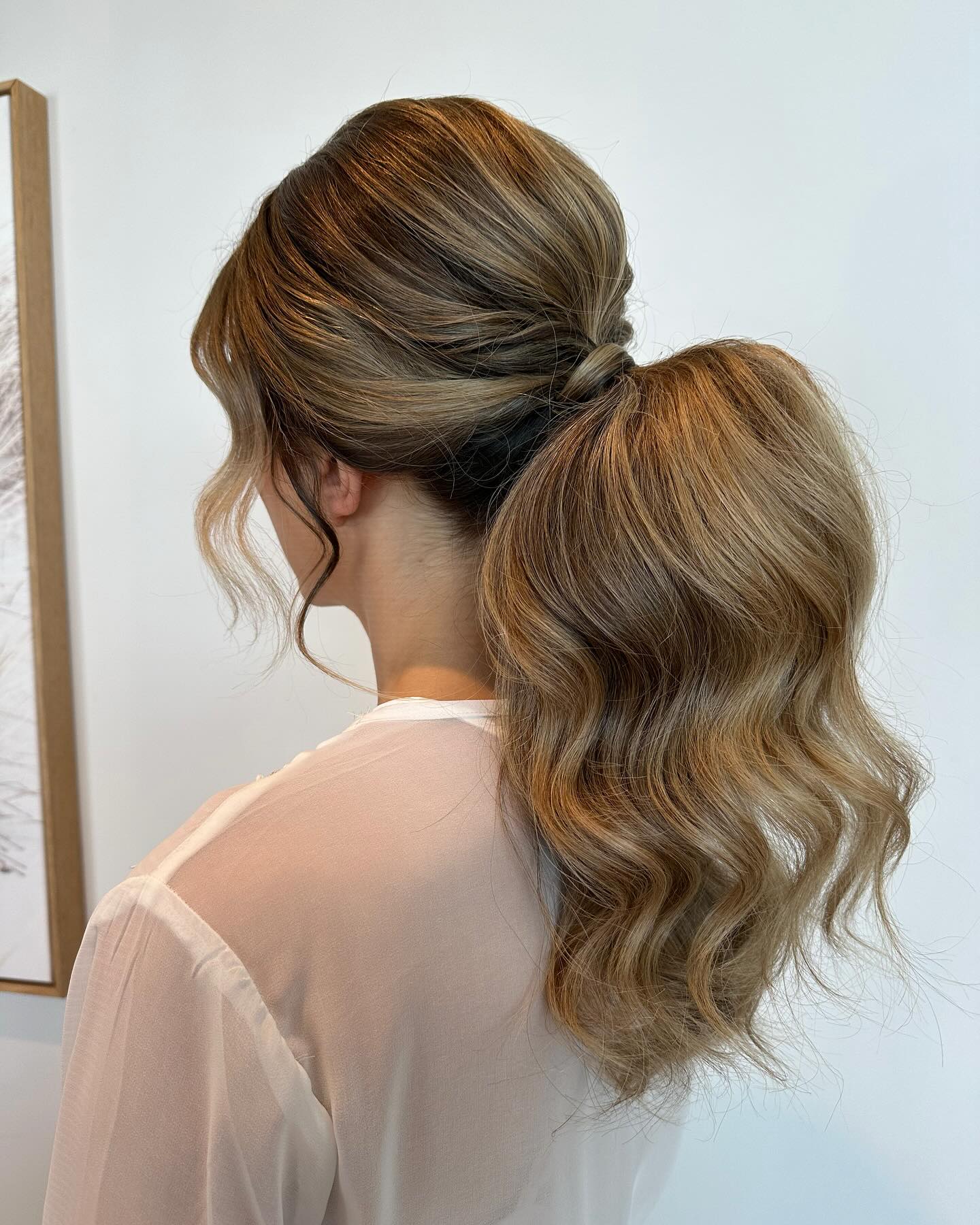voluminous low curled ponytail