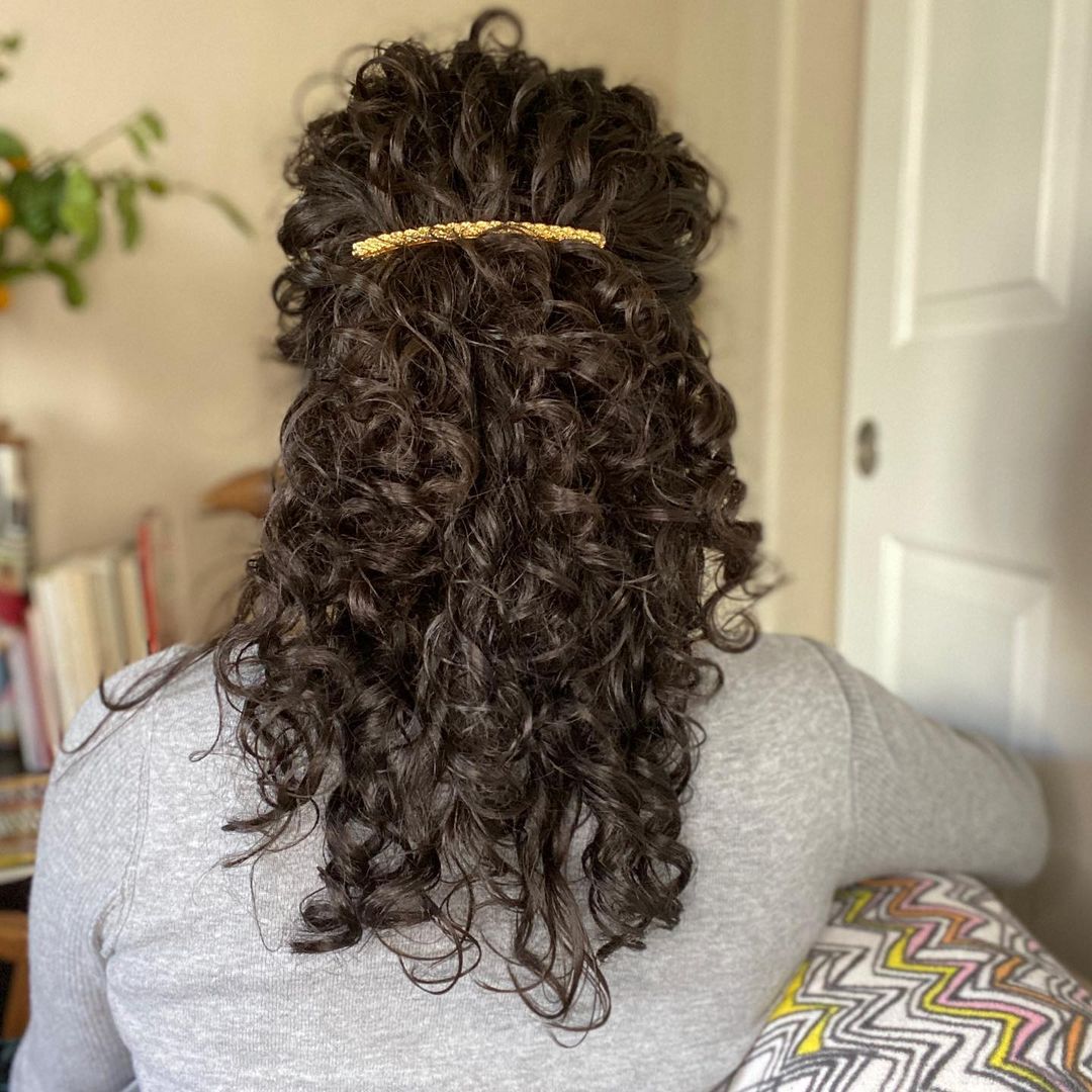 curly hair updo with a hair barrette 