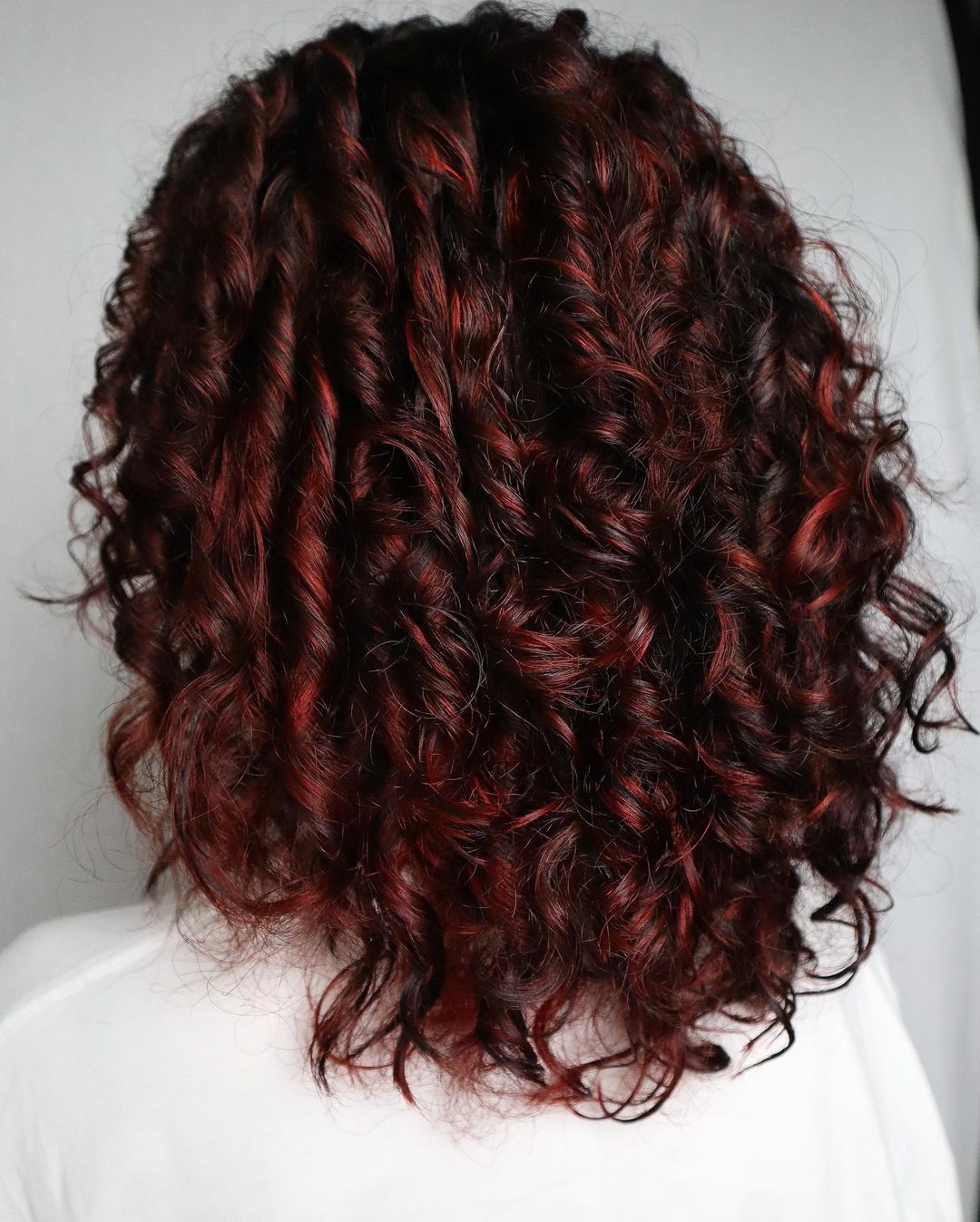 mèches rouges sur cheveux bouclés