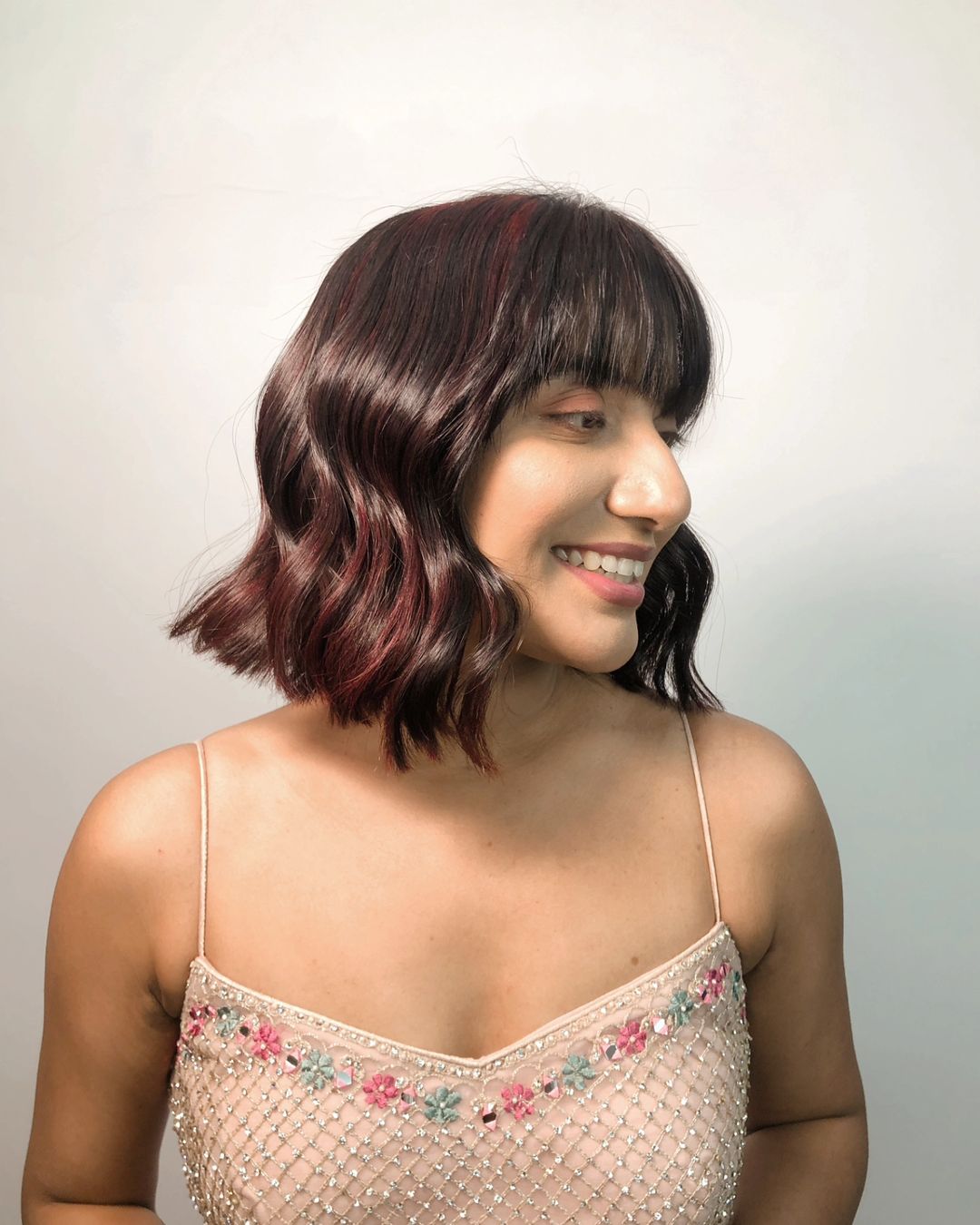 blunt bob with bangs and cherry cola highlights