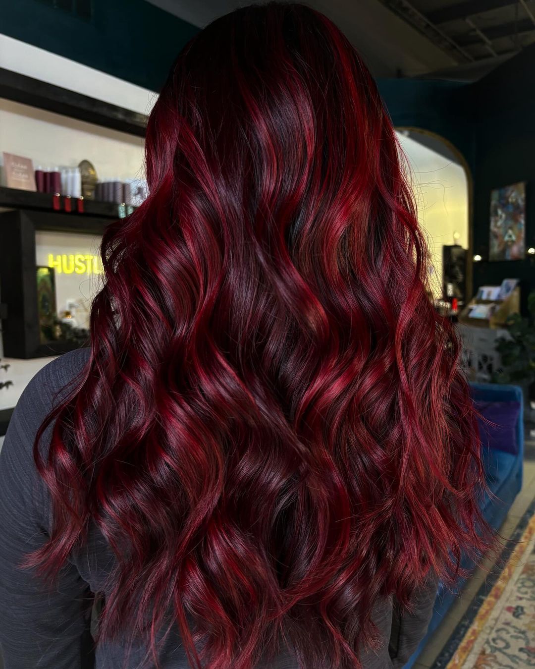 cerise cola avec des reflets rouges sur des cheveux longs et ondulés