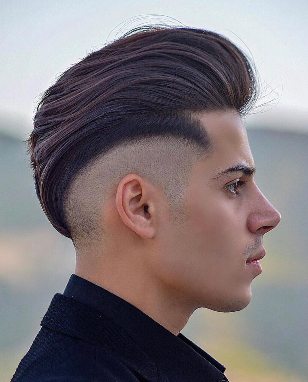high taper fade with textured brushed up hair