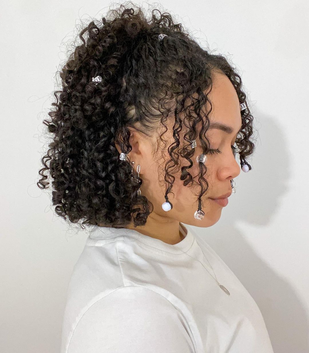 half-up short curly ponytail with beads