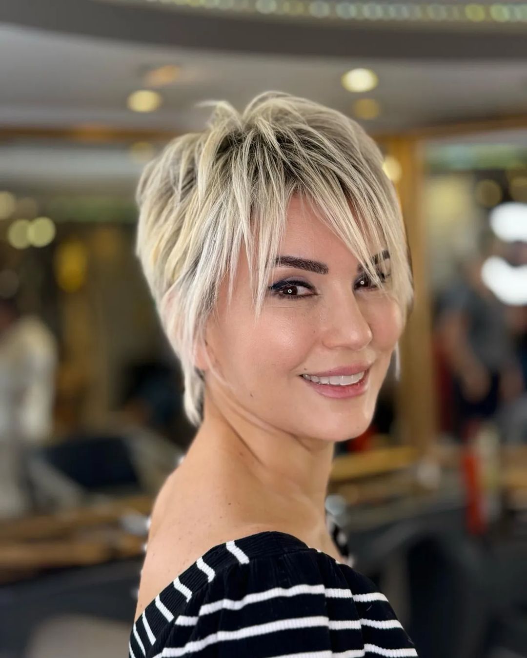 blonde layered pixie cut with dark roots