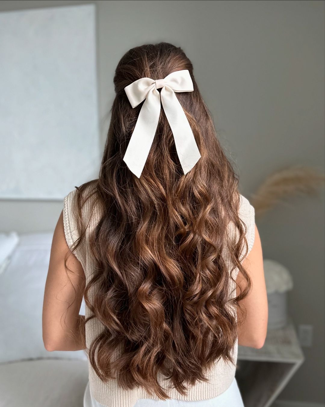 cheveux ondulés à demi relevés avec un nœud