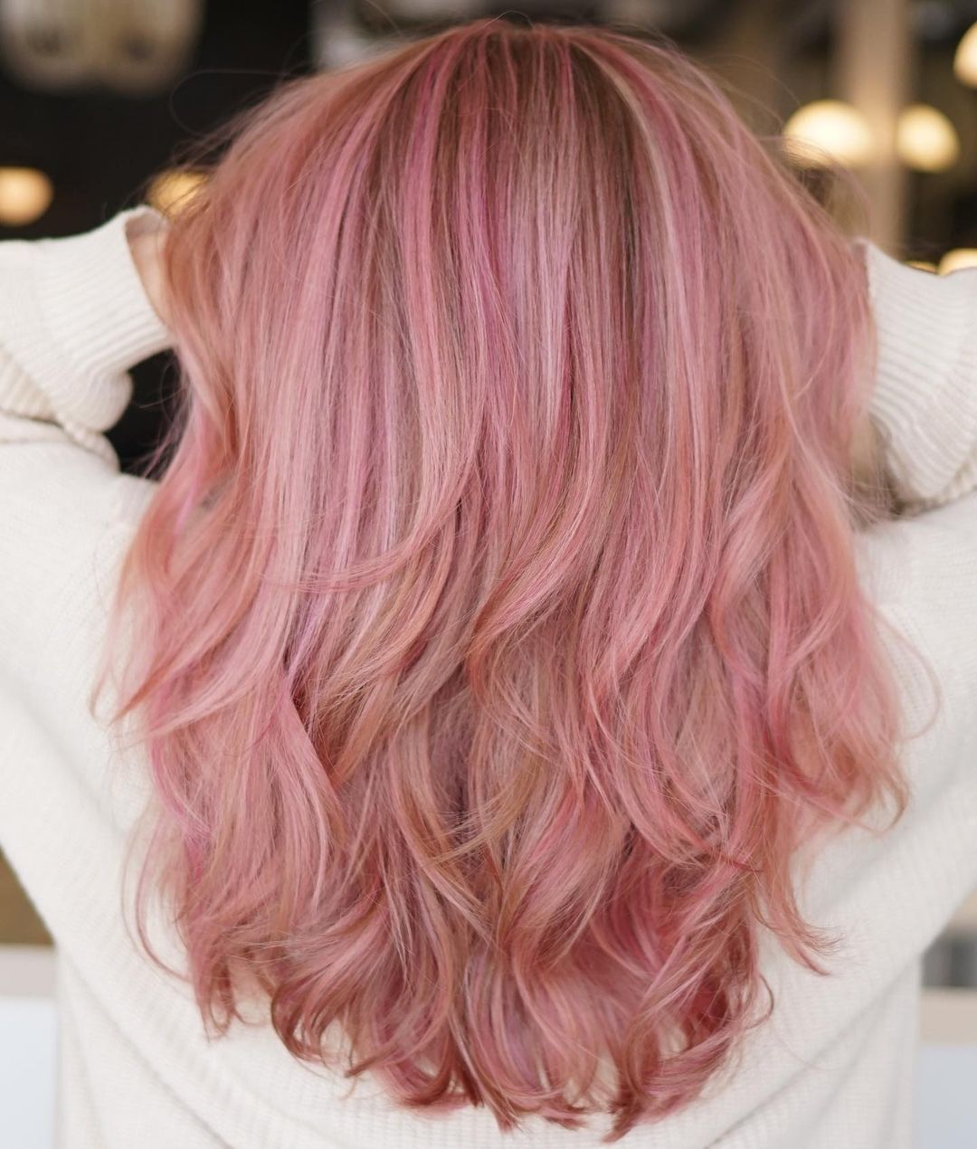 capelli rosa pastello stratificati con una ciocca di denaro rosa chiaro