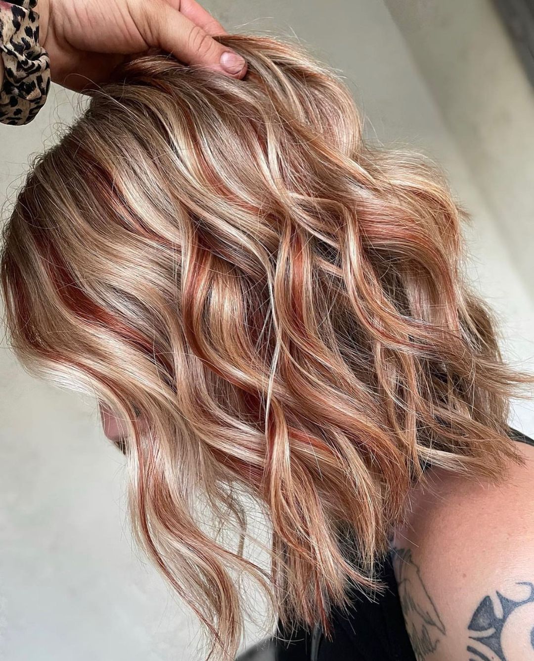 kort golvend blond haar met koperrode lowlights