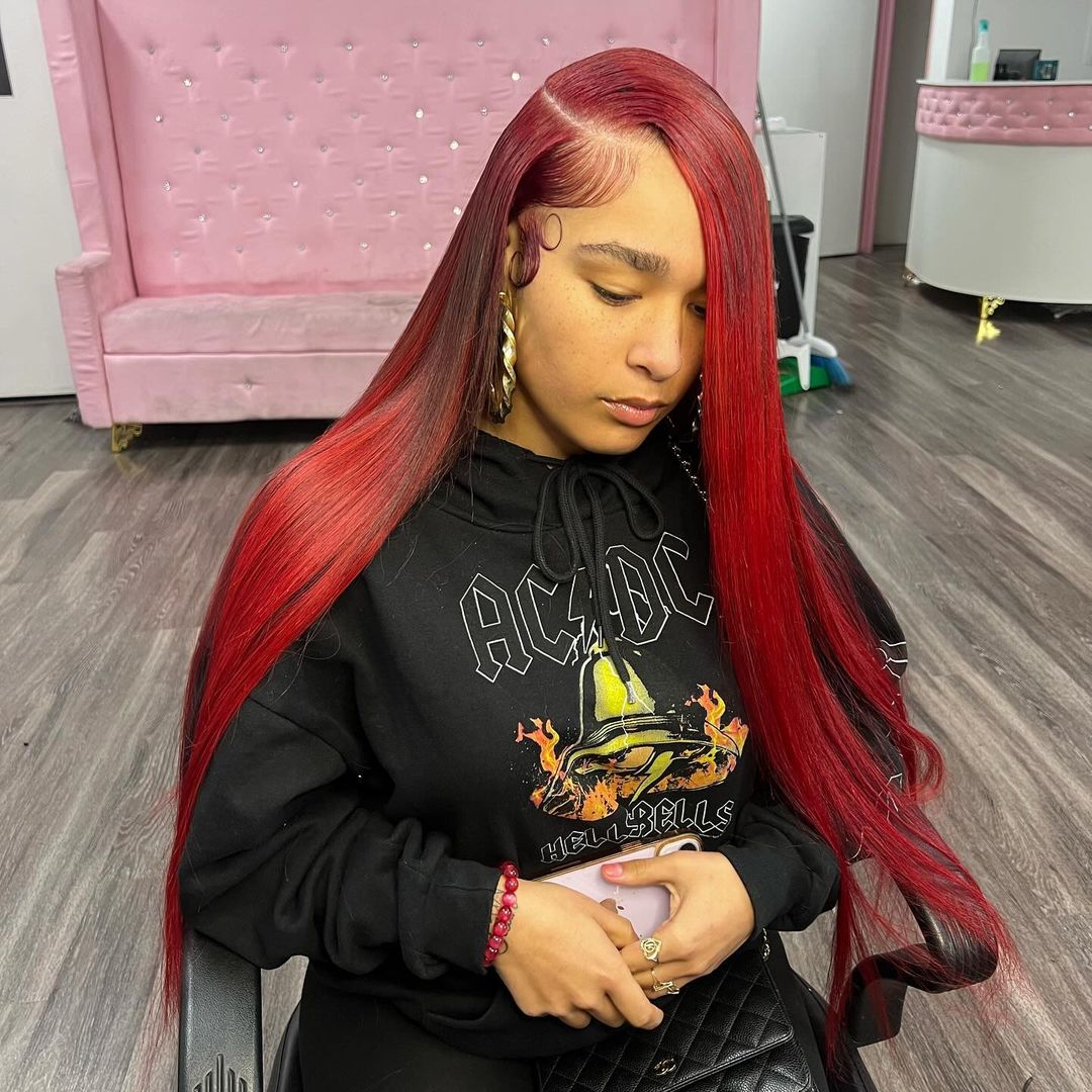 sleek straight red weave with a deep side part