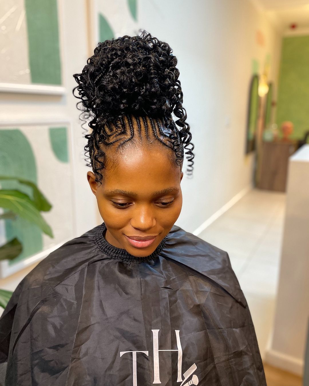 tribal cornrow braids into a voluminous curly bun