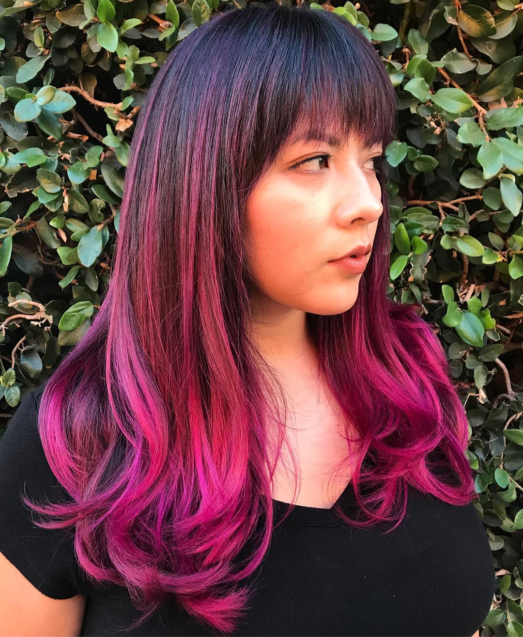 vibrant fuschia balayage on straight hair with bangs