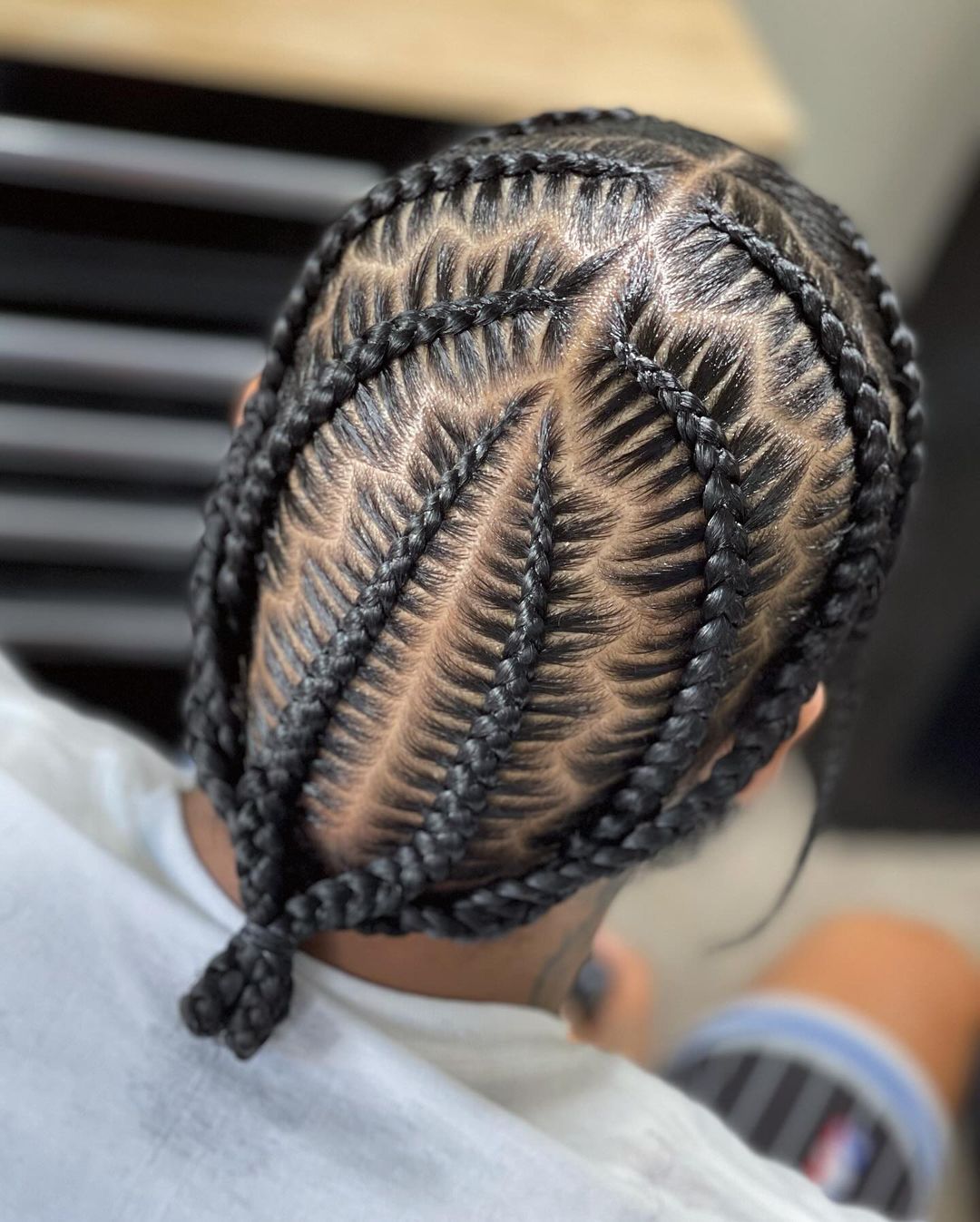 fishtail braids with zig zag parting into low bun