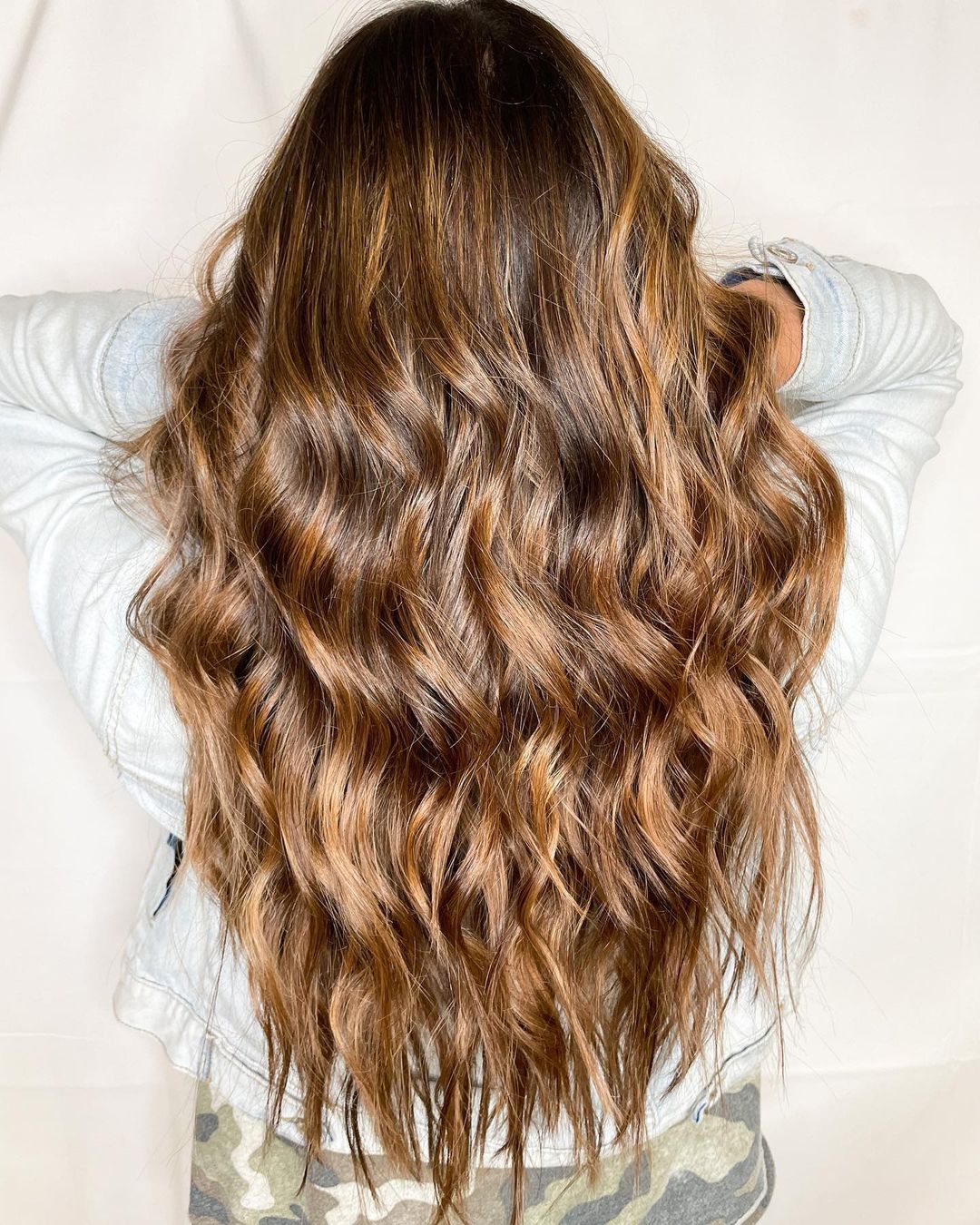 golden caramel balayage on long tousled wavy hair