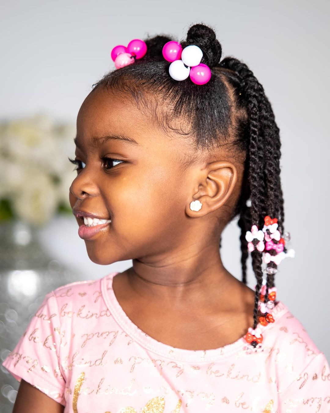 half-up sleek space buns with beaded twists