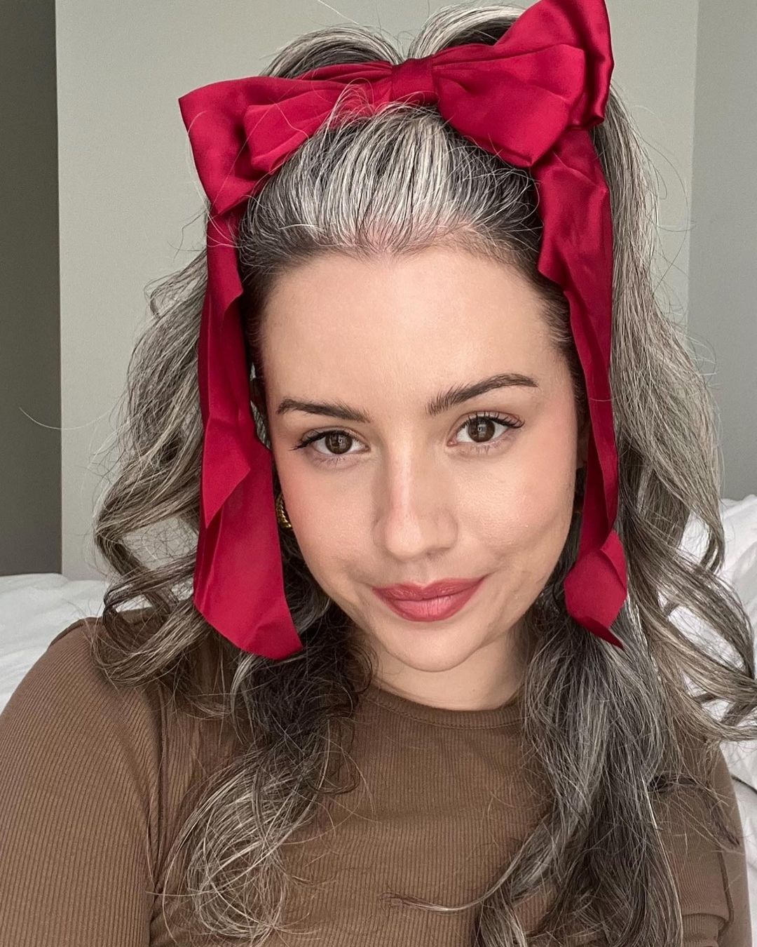 meio penteado com um grande laço vermelho