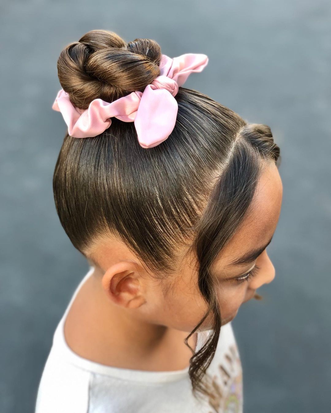 chignon haut avec des pièces encadrant le visage