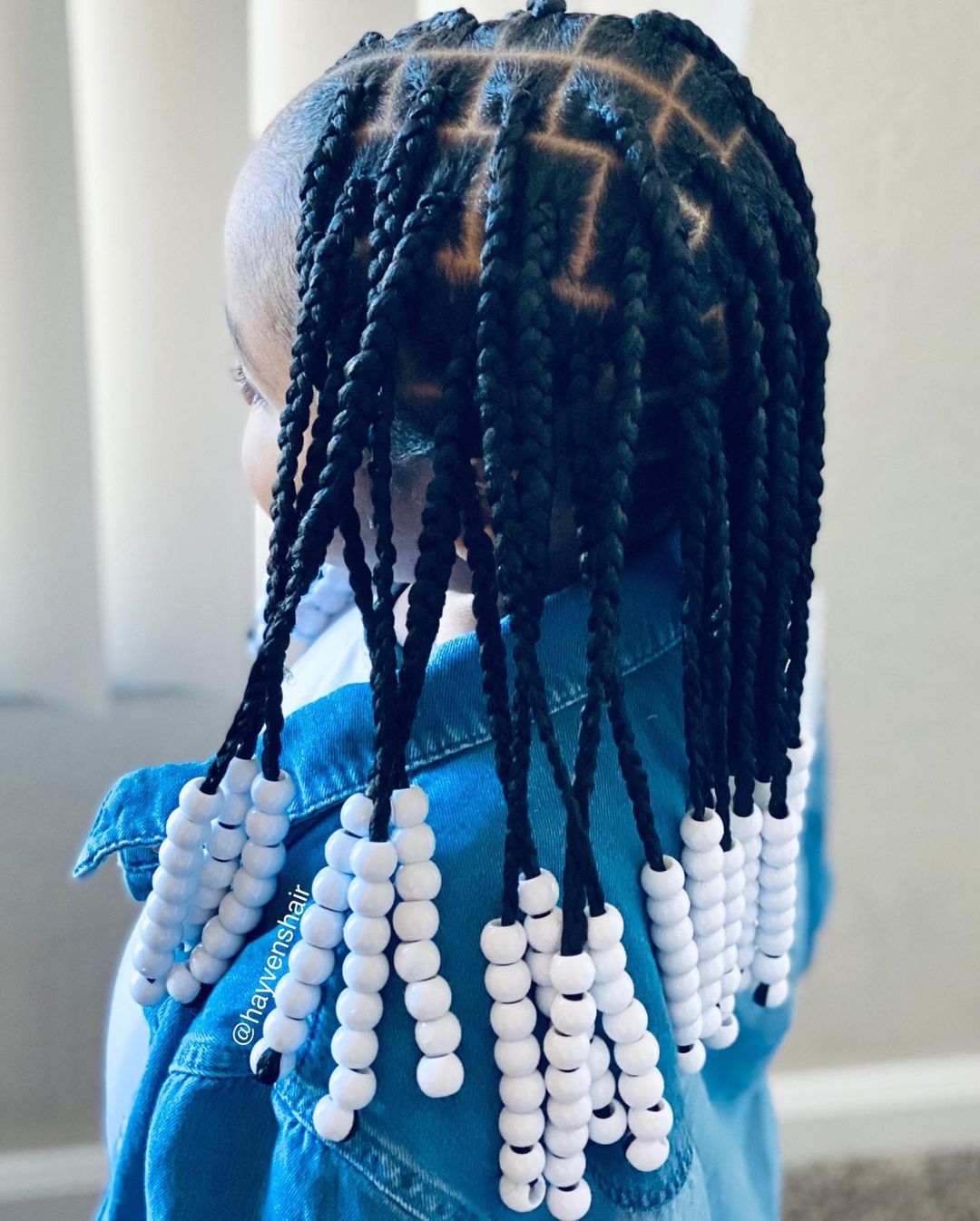 knooploze box braids met witte haarkralen