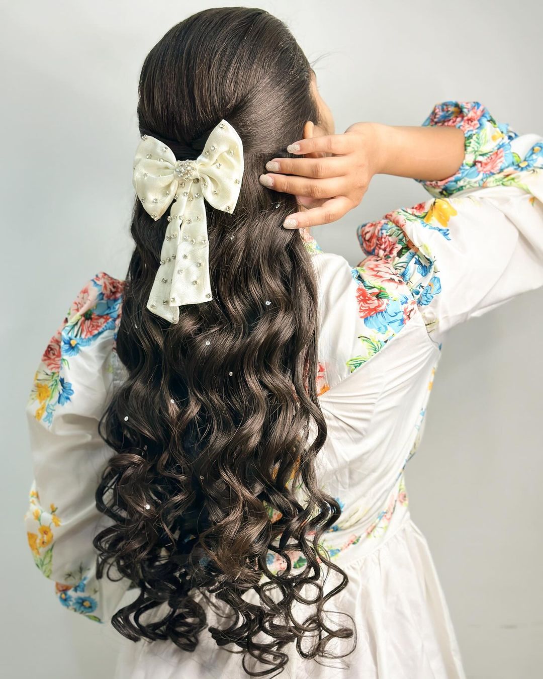 cabelo comprido meio penteado com um laço e pérolas