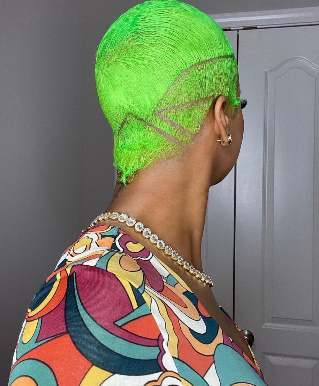 Pixie vert fluo avec côtés effilés et coupe franche en dessous de la tête