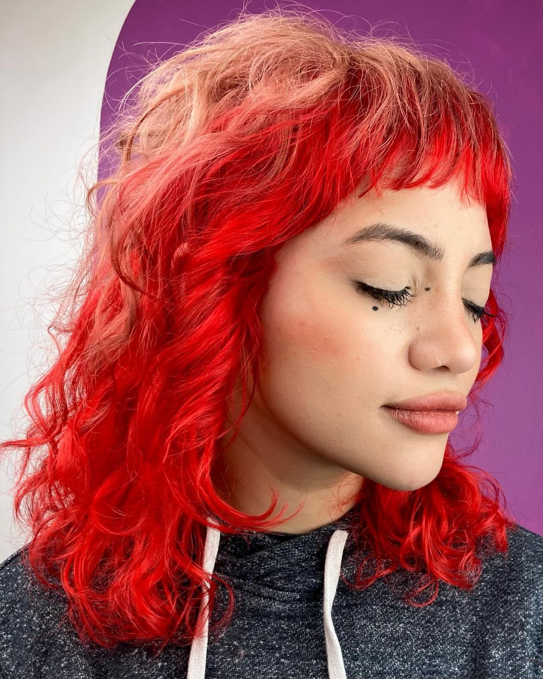 red strawberry blonde curly color block hair