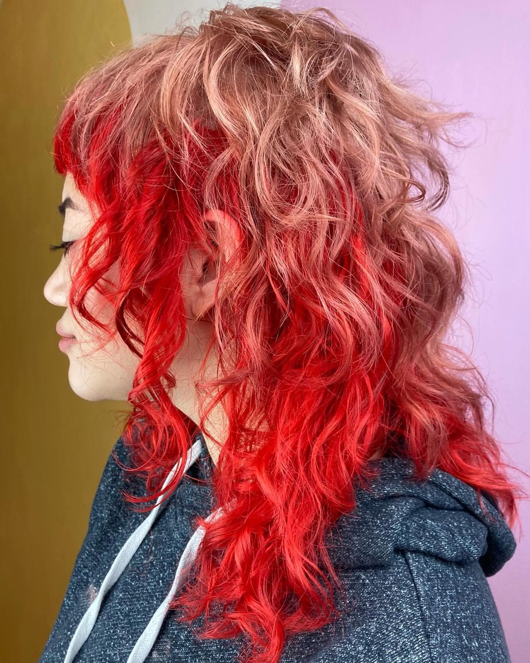 red strawberry blonde curly color block hair