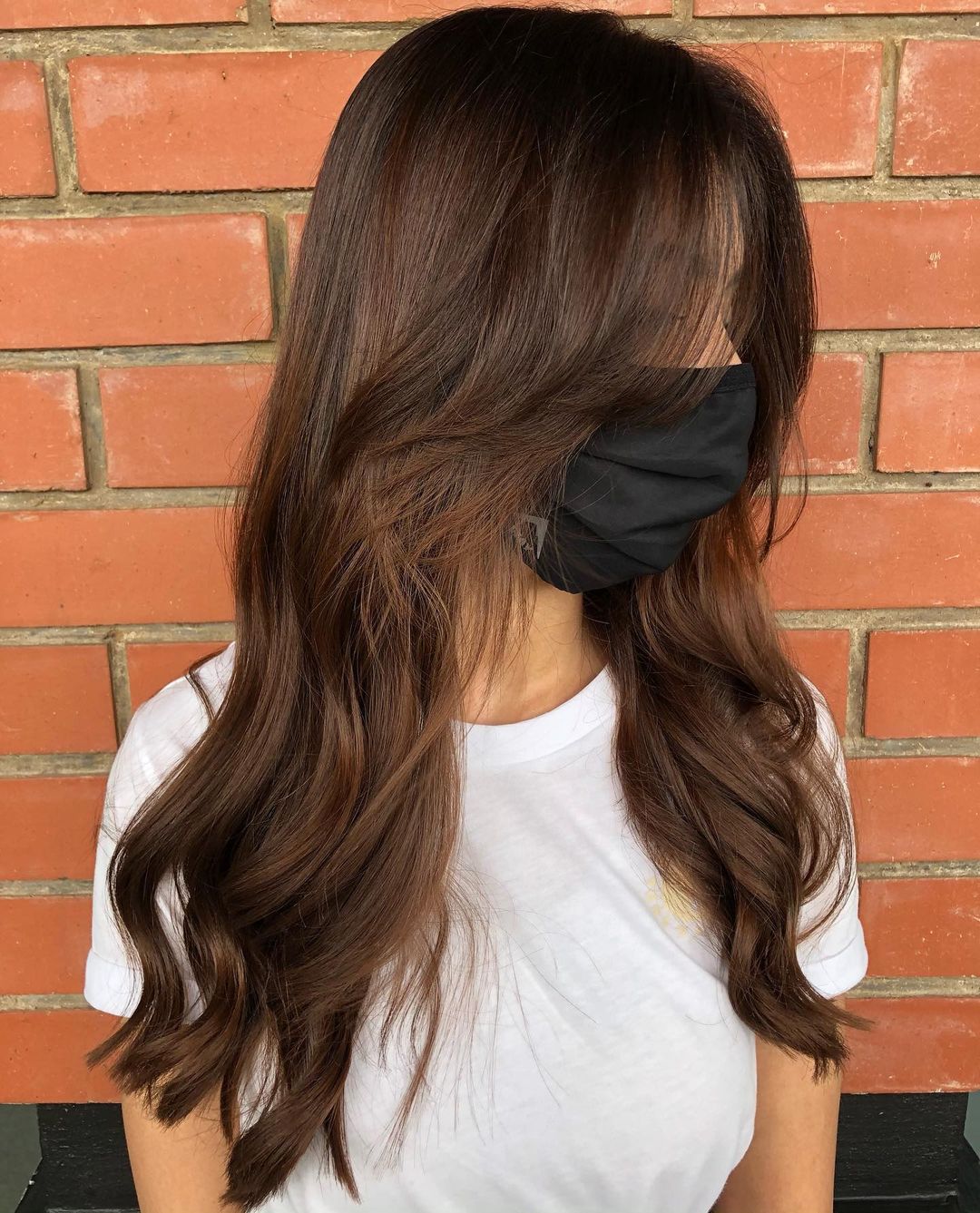 warm chocolate brown color on soft waves with curtain bangs