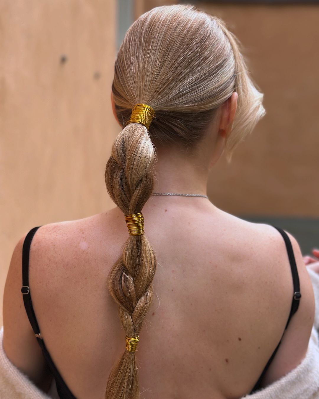 queue de cheval tressée avec de jolis ornements de cheveux dorés