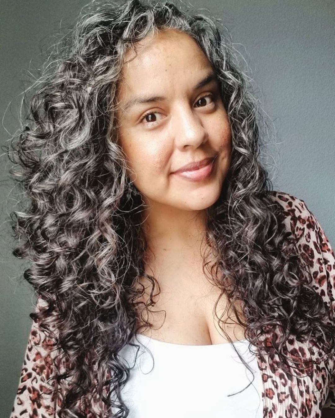 pelo rizado gris con mechas castaño oscuro