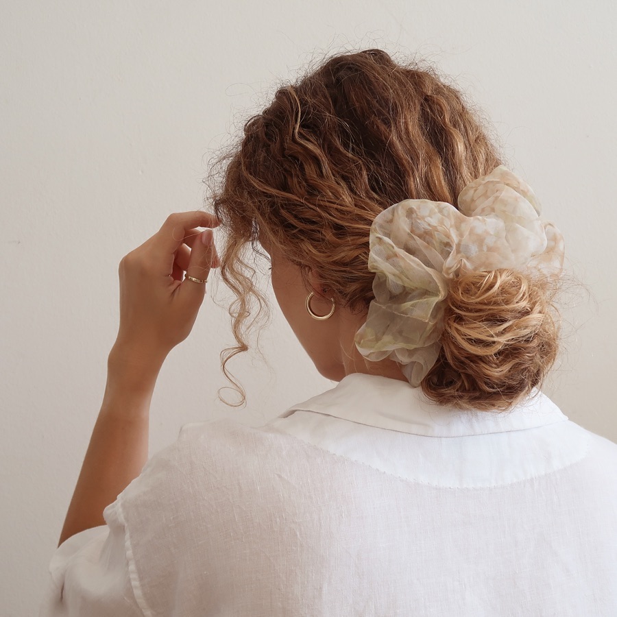 low curly bun with a scrunchie