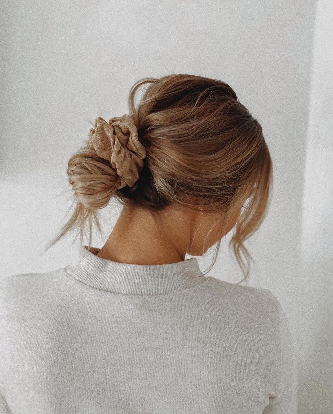 low messy bun with an oversized scrunchie