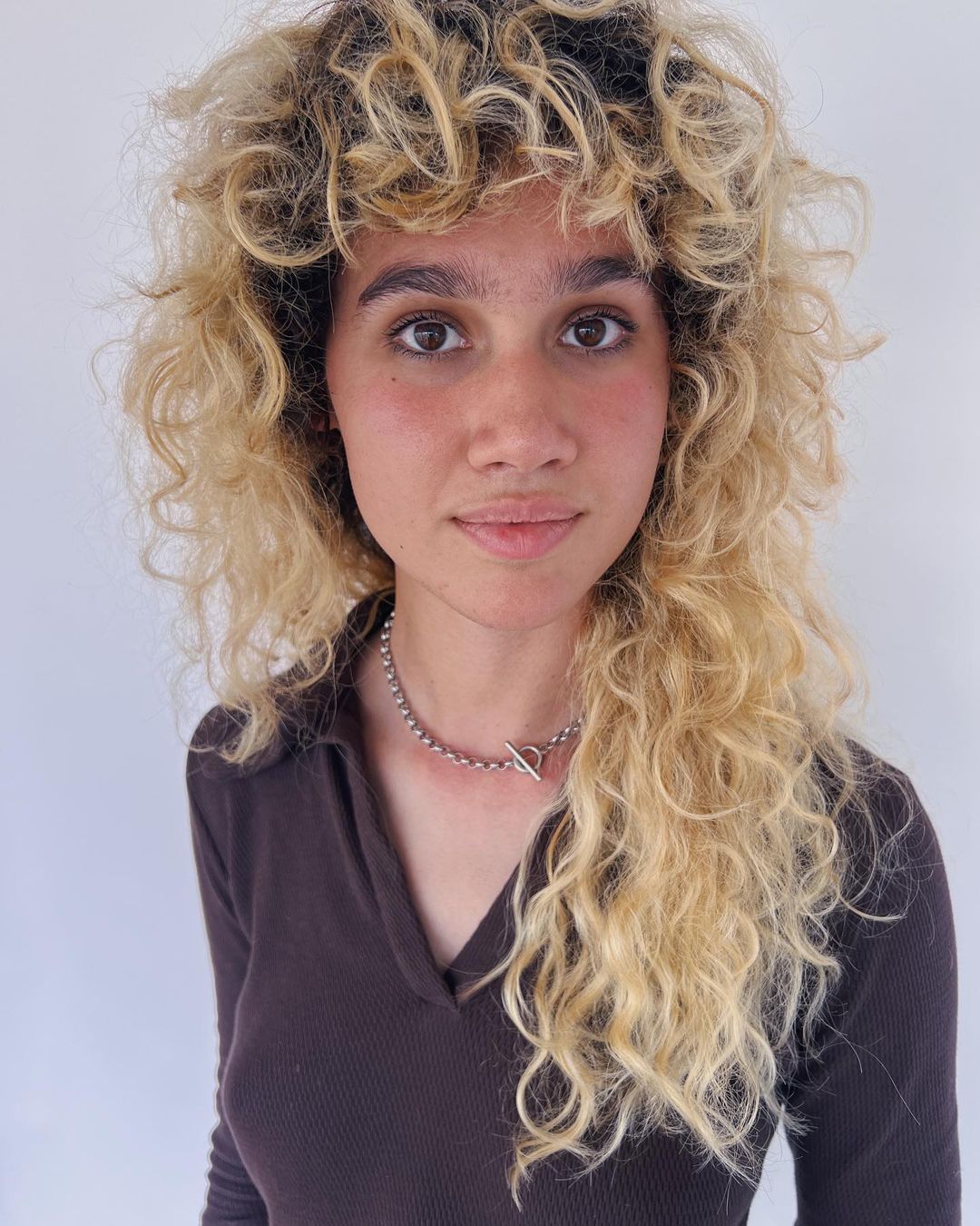 messy blonde curls with bangs