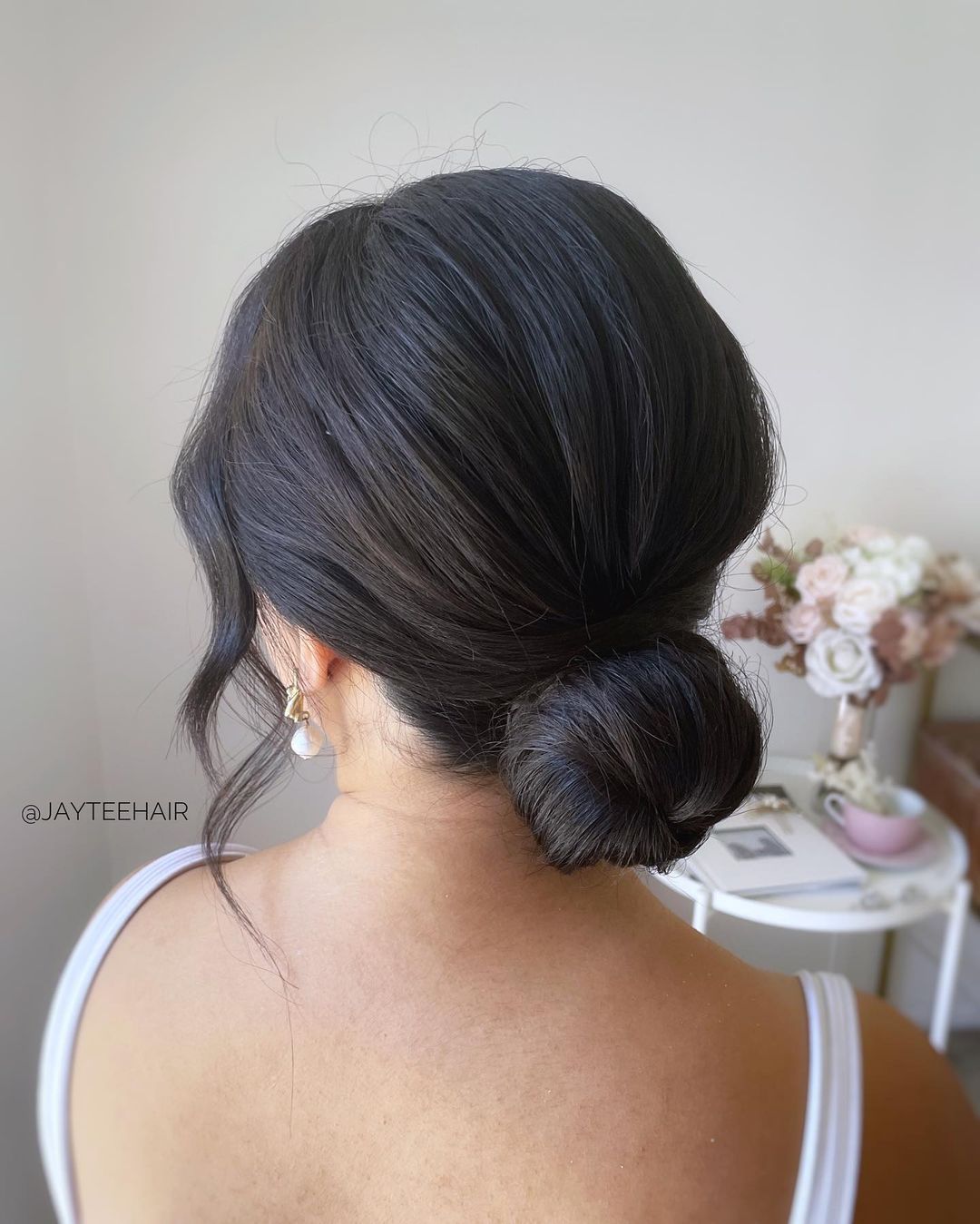 chignon liscio e sottile con pezzi morbidi che incorniciano il viso