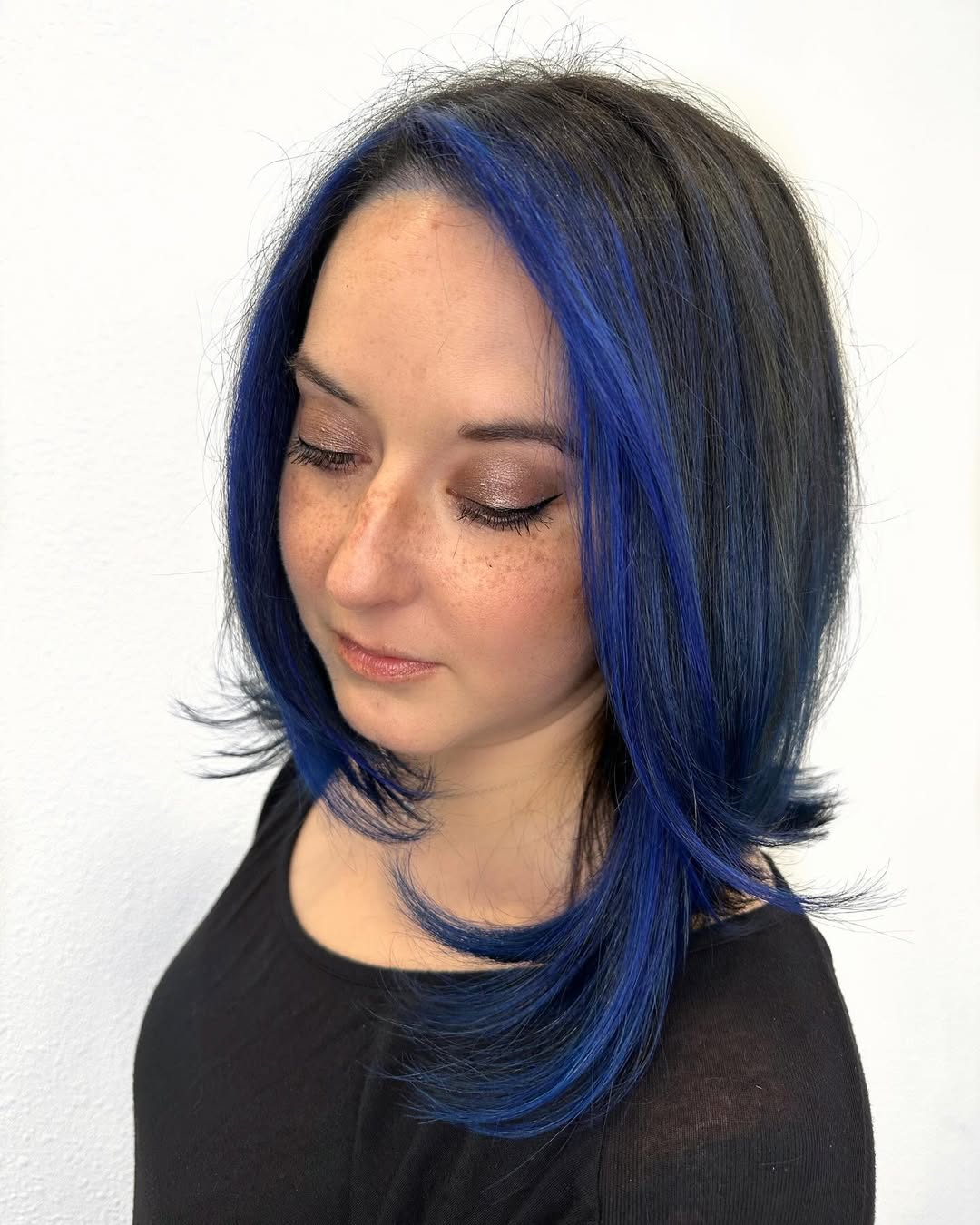 dark angled lob with vivid blue face-framing highlights