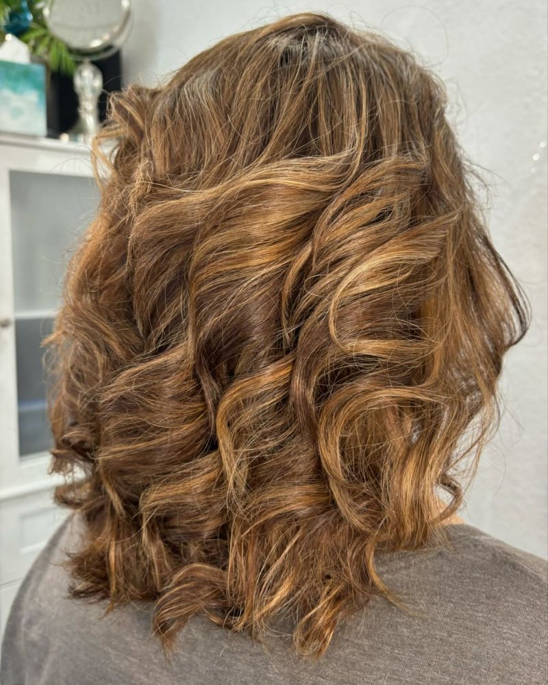 Cabelo encaracolado com madeixas douradas