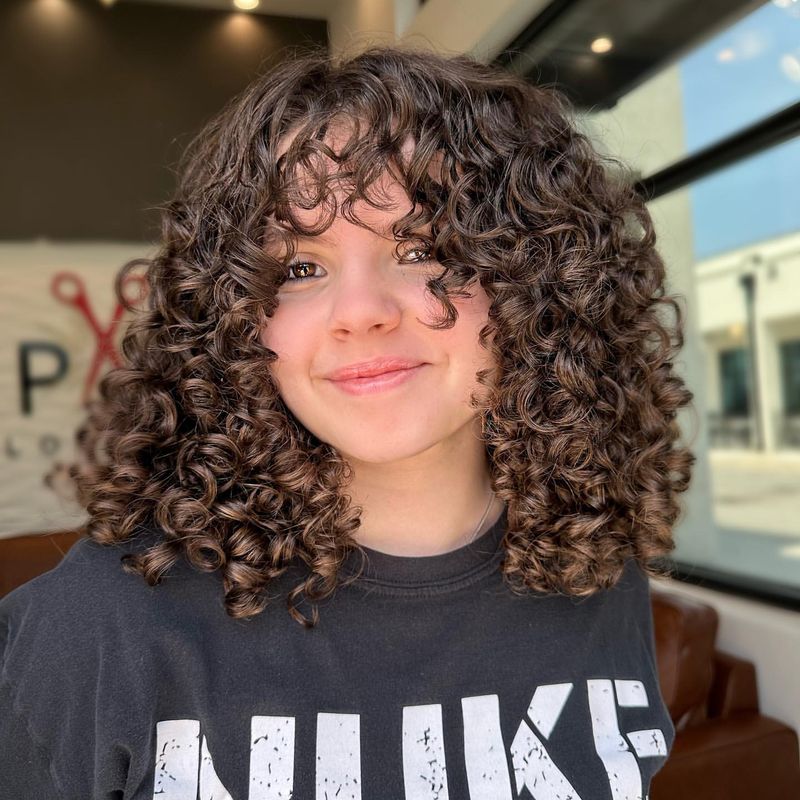 Voluminous Curls and Wispy Bangs